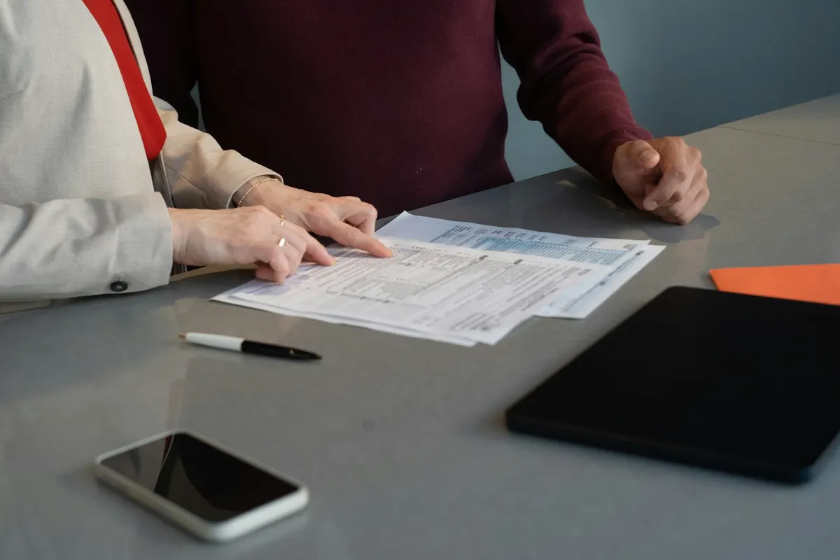 Two people going line by line through a printed billing statement at a meeting table, which is where most Google Cloud cost decisions actually get discovered